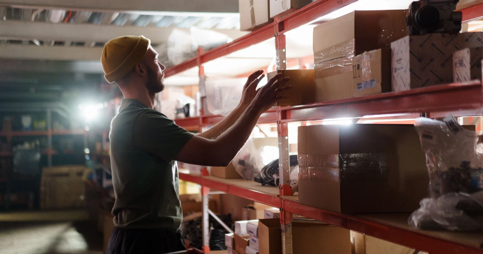 Worker picking a carton from storage shelves