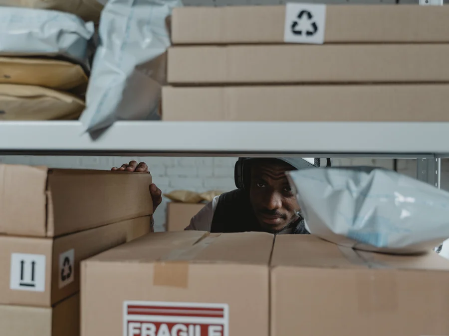 Warehouse worker inspecting parcels on shelves