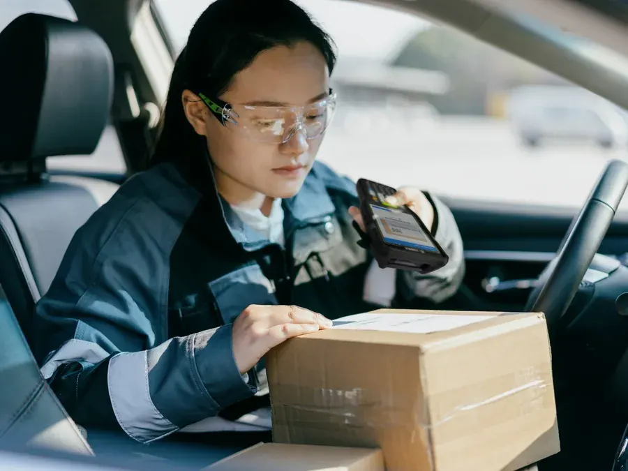 Field worker in a van scanning a parcel with a mobile computer