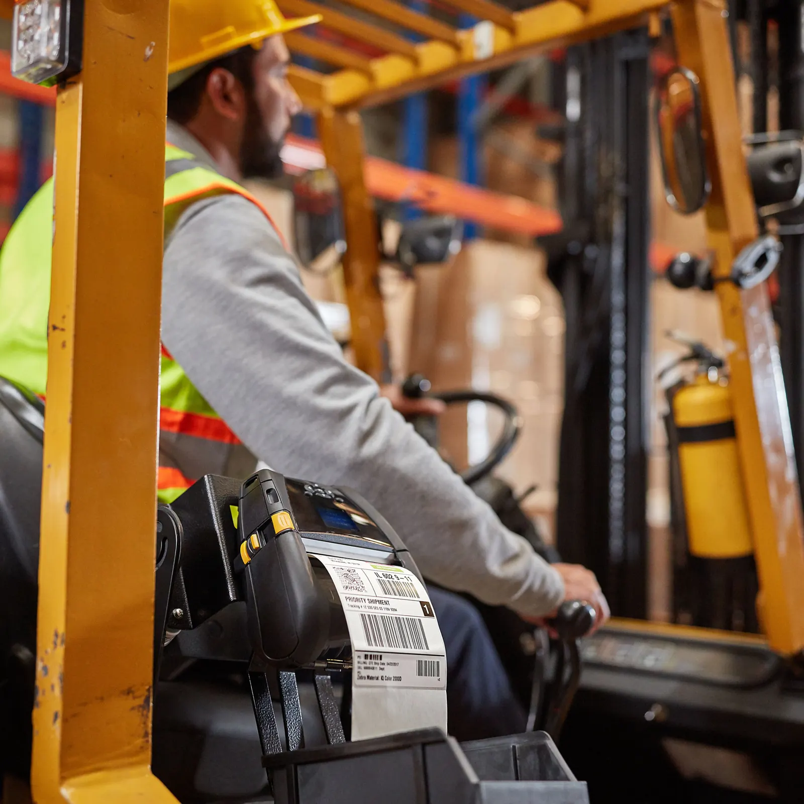 Forklift driver moving pallets between warehouse racks