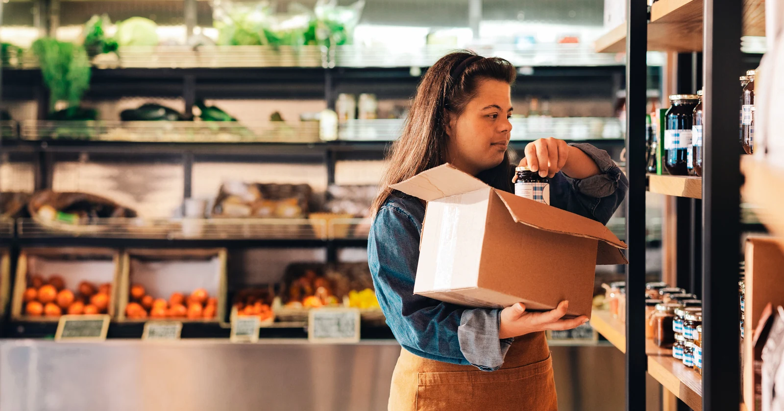 Grocery store employee replenishing products on a shelf