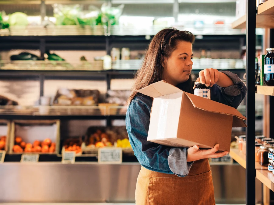 Grocery store employee replenishing products on a shelf
