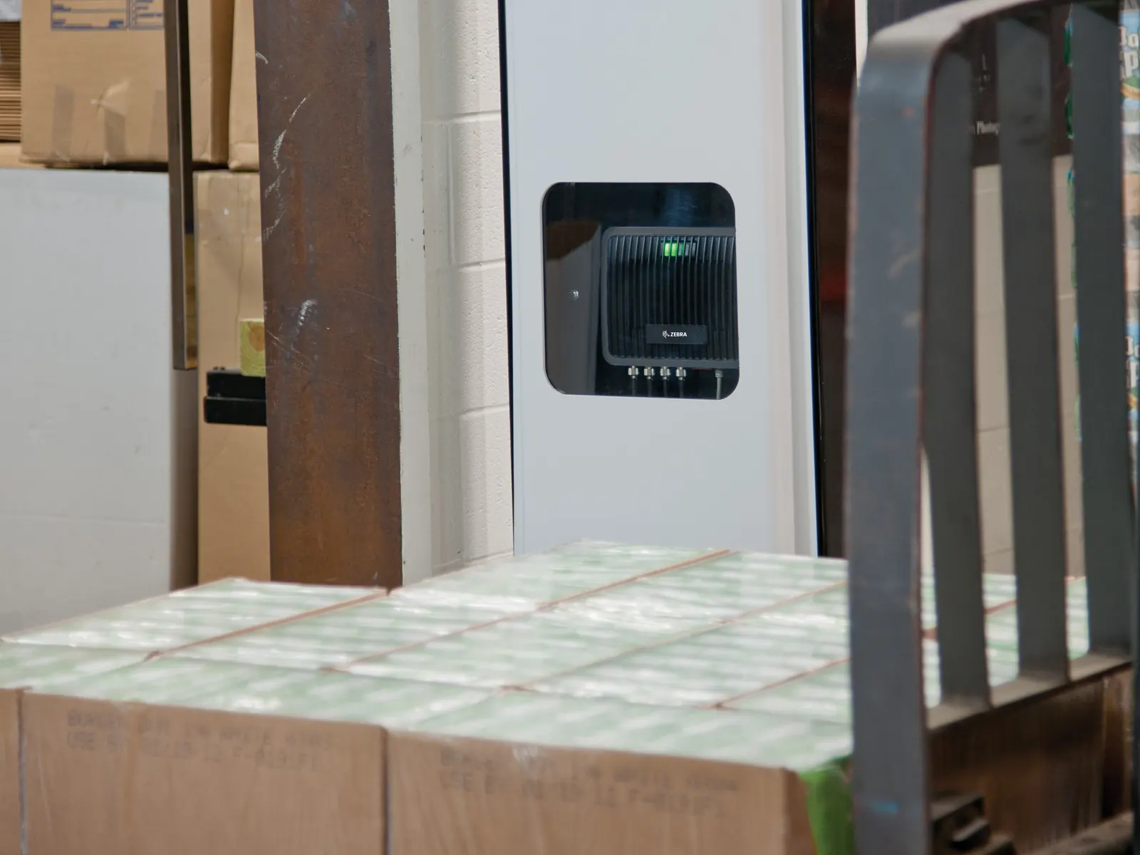 Fixed RFID reader mounted by a back-of-store door above stacked cartons