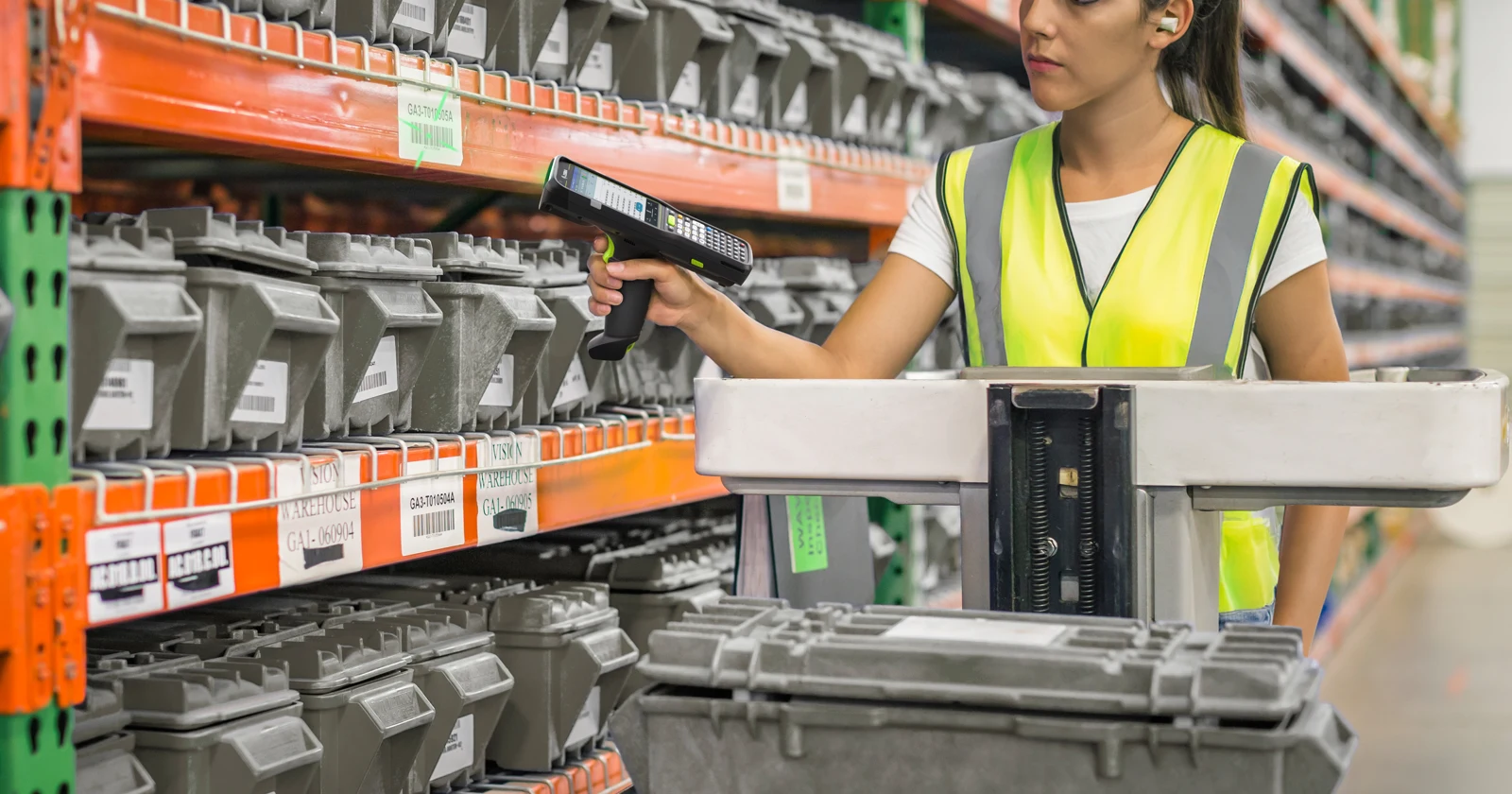 Worker scanning warehouse shelf labels with a Zebra handheld